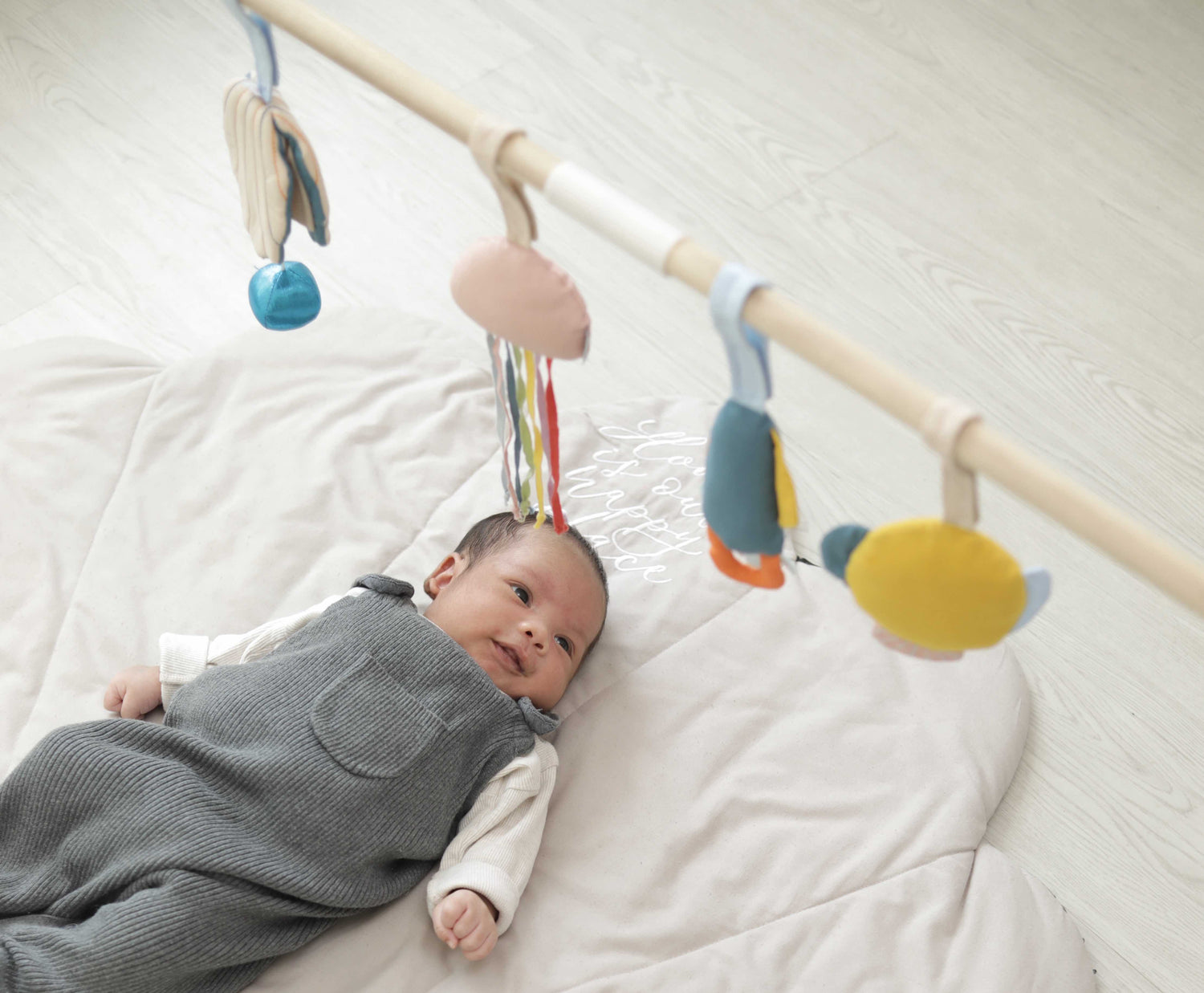 Newborn baby looking at hanging mobile toys