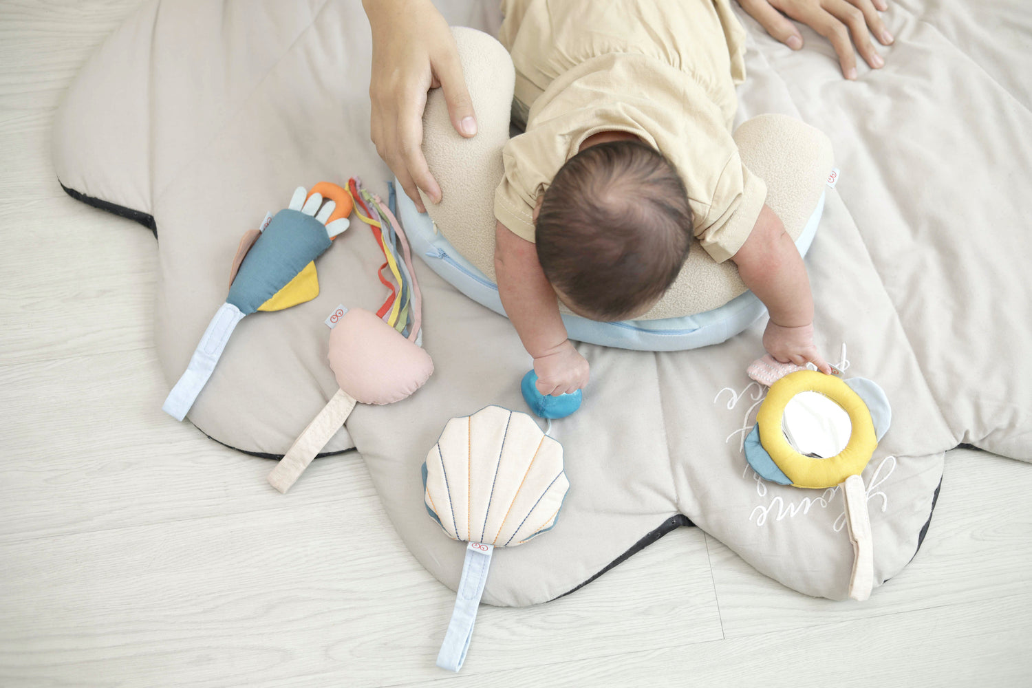 Baby using the Dual Tummy Time Pillow while playing with the Sensory Pads