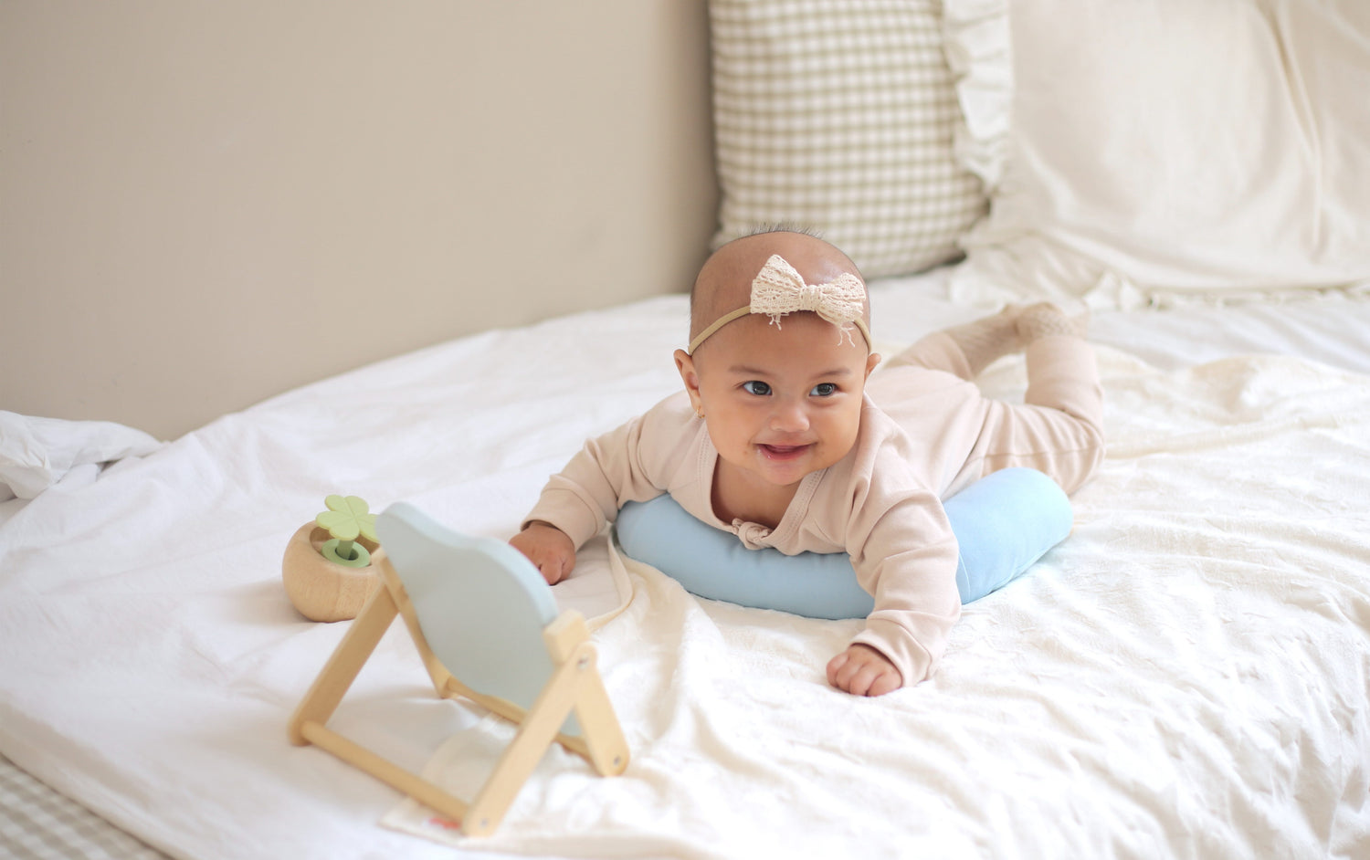 Baby smiling during tummy time while using the Tummy Time Pillow and Tummy Time Stand